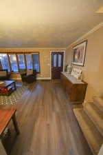 Entrance foyer featuring wood finished floors, stairs, and crown molding