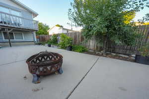 Fenced backyard featuring a fire pit and a patio area