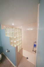 Bathroom with a textured ceiling and a walk in shower