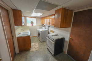 Laundry area featuring washing machine and clothes dryer and baseboards