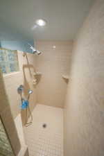 Bathroom with tiled shower and recessed lighting