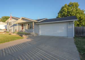 View of front of house with driveway, a garage, and covered porch