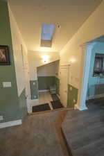 Hall featuring a skylight, light carpet, decorative columns, and light tile patterned flooring
