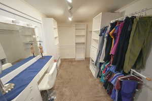Massive walk in closet featuring carpet flooring