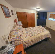 Bedroom featuring a closet, a textured ceiling, and carpet