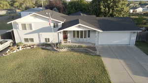 View of front of home with an attached garage, driveways on both sides of house, and a porch