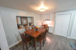 Dining space with a textured ceiling and wood finished floors