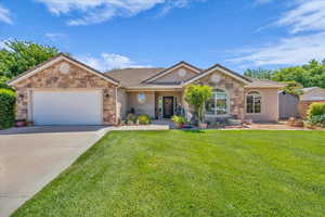 Ranch-style home featuring stone siding, concrete driveway, a garage, a front yard, and stucco siding