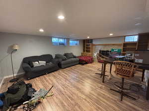 Living area with wood finished floors, recessed lighting, and a glass covered fireplace