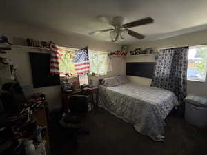 Carpeted bedroom with a ceiling fan