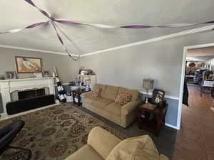 Tiled living area with crown molding, a textured ceiling, and a fireplace