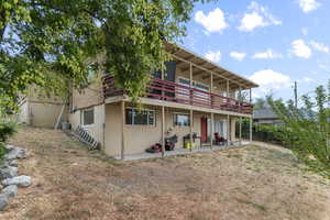 Rear view of house featuring a patio, stucco siding, and a deck