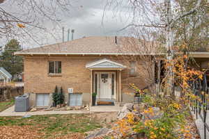 View of front of house featuring roof with shingles and brick siding
