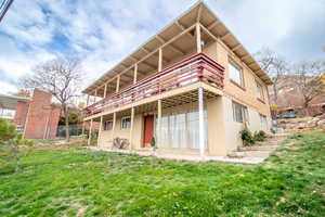Rear view of property featuring stucco siding, a patio area, and stairway