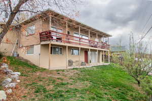 Rear view of property featuring a lawn, a patio area, and a deck