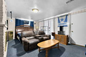Bedroom with a textured ceiling and carpet