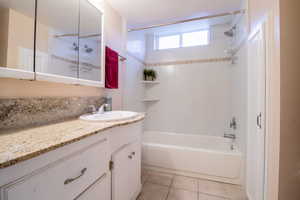 Bathroom featuring vanity, shower / bathtub combination, and light tile patterned floors