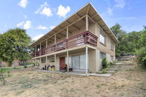Back of property featuring a patio area, a deck, and stucco siding