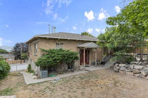 Rear view of property featuring brick siding and a shingled roof