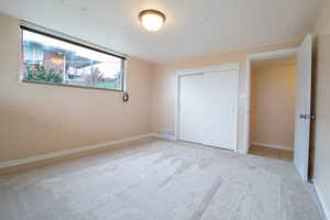 Unfurnished bedroom featuring light colored carpet and a closet