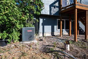 View of side of home featuring a central AC unit and a balcony
