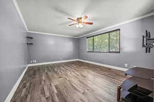 Unfurnished room featuring ceiling fan, ornamental molding, and wood finished floors