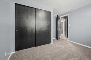 Unfurnished bedroom featuring light colored carpet and a closet