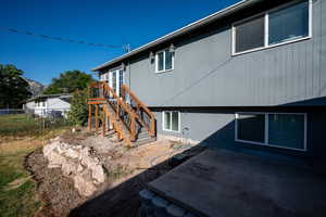 Back of property with stairway, a patio area, and a wooden deck