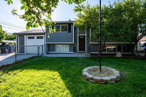 Raised ranch with concrete driveway and a garage