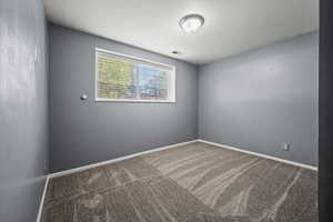Carpeted empty room with baseboards