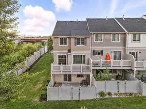 Back of property with a gate, a fenced backyard, a shingled roof, and stucco siding