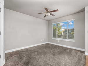 Empty room with carpet floors and a ceiling fan