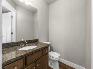 Half bathroom featuring vanity and wood finished floors