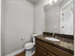 Half bath featuring vanity and wood finished floors