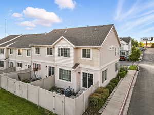 Rear view of property with a residential view, stucco siding, a gate, roof with shingles, and a fenced backyard