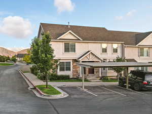 View of property with covered and uncovered parking