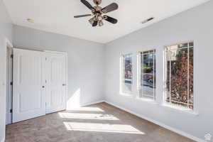 Unfurnished bedroom with carpet, a closet, and a ceiling fan