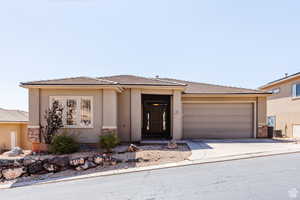 Prairie-style home with stucco siding, driveway, a garage, and a tile roof