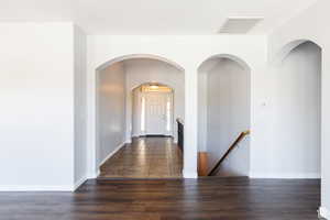 Foyer entrance with wood finished floors and arched walkways