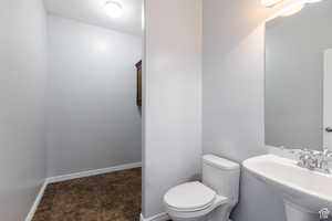 Half bathroom featuring toilet and baseboards