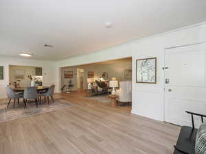 Dining room with crown molding and light wood finished floors