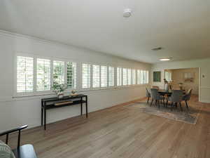 Dining area with crown molding and light wood-style floors