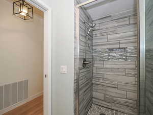 Bathroom featuring a shower stall and wood finished floors