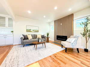 Living room with recessed lighting, light wood finished floors, and a fireplace