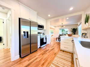 Kitchen with appliances with stainless steel finishes, tasteful backsplash, light countertops, white cabinetry, and recessed lighting