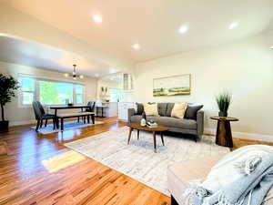 Living area with light wood-style floors, recessed lighting, and arched walkways