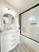 Bathroom featuring vanity, tile walls, enclosed tub / shower combo, backsplash, and tile patterned flooring