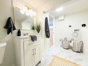 Bathroom featuring vanity, marble look tiles, and decorative backsplash