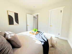 Bedroom featuring light colored carpet and baseboards