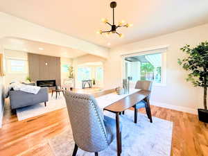 Dining room featuring arched walkways, a chandelier, healthy amount of natural light, light wood finished floors, and recessed lighting